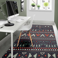 Tribal elephant area rug, dark base with red, cream, and teal pattern bands