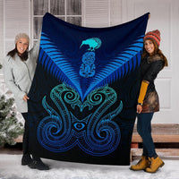 Blue Maori manaia blanket with teal tribal design, held by two people indoors