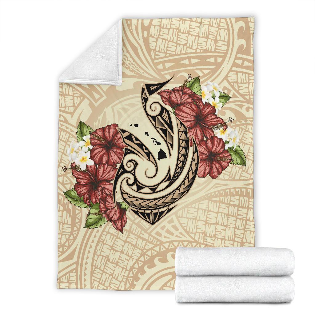 Beige blanket with fish hook and hibiscus plumeria print; folded white throw included