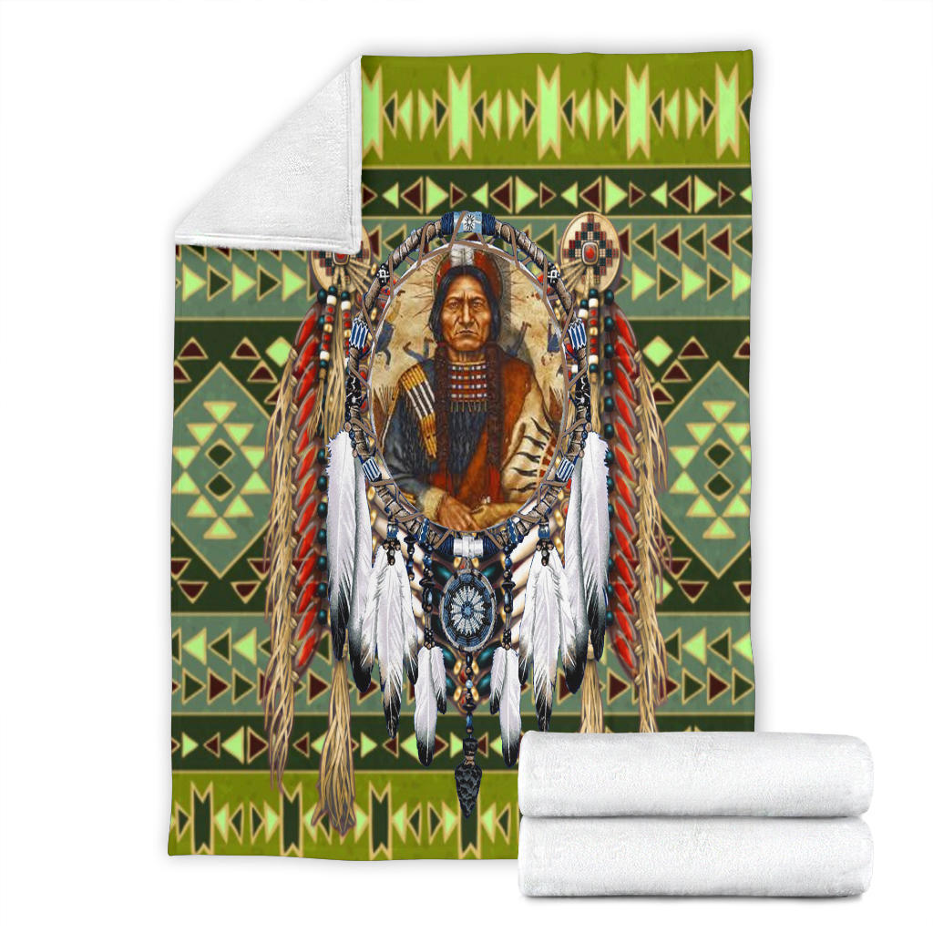 Green multicolor chief blanket folded with rolled white blankets beside it