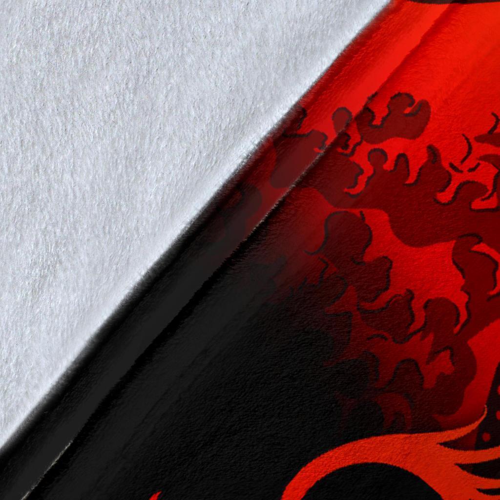 Close-up of black-and-red wave and floral blanket print texture