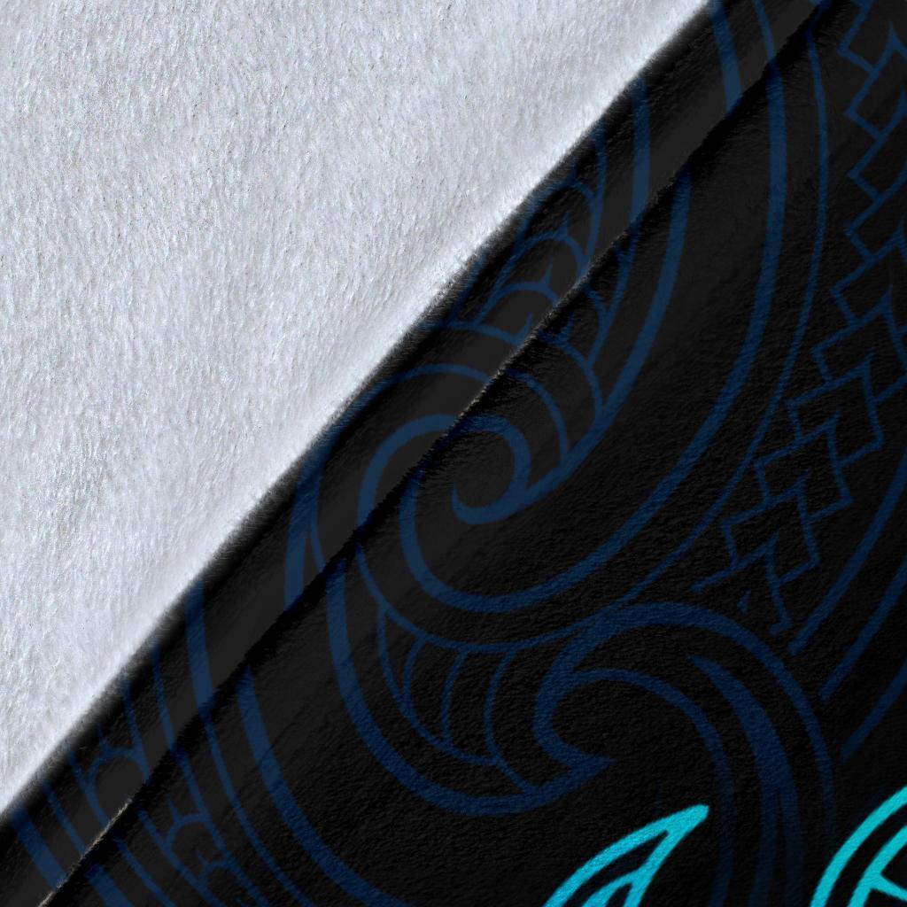 Close-up of blue blanket fabric with teal tribal pattern and textured weave
