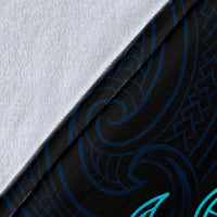Close-up of blue blanket fabric with teal tribal pattern and textured weave