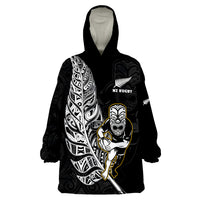 Black wearable blanket hoodie with hood and large NZ Rugby Maori-style graphic on front