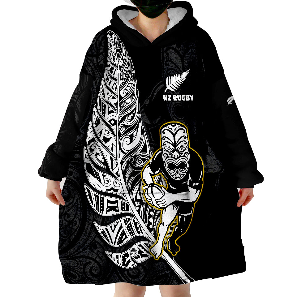 Black wearable blanket hoodie with hood, front NZ Rugby print, and Maori warrior graphic