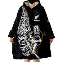 Black wearable blanket hoodie with hood, front NZ Rugby print, and Maori warrior graphic