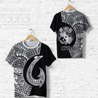 Black Tonga graphic T-shirt on hanger: back crest, shield, and ITUPOU text