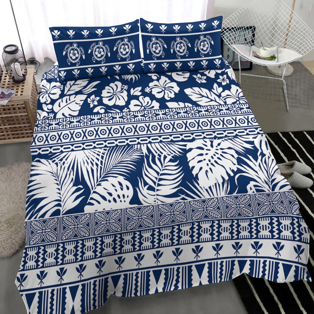 Navy bedding set with layered tropical florals, leaves, and geometric stripe bands