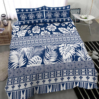 Navy bedding set with layered tropical florals, leaves, and geometric stripe bands